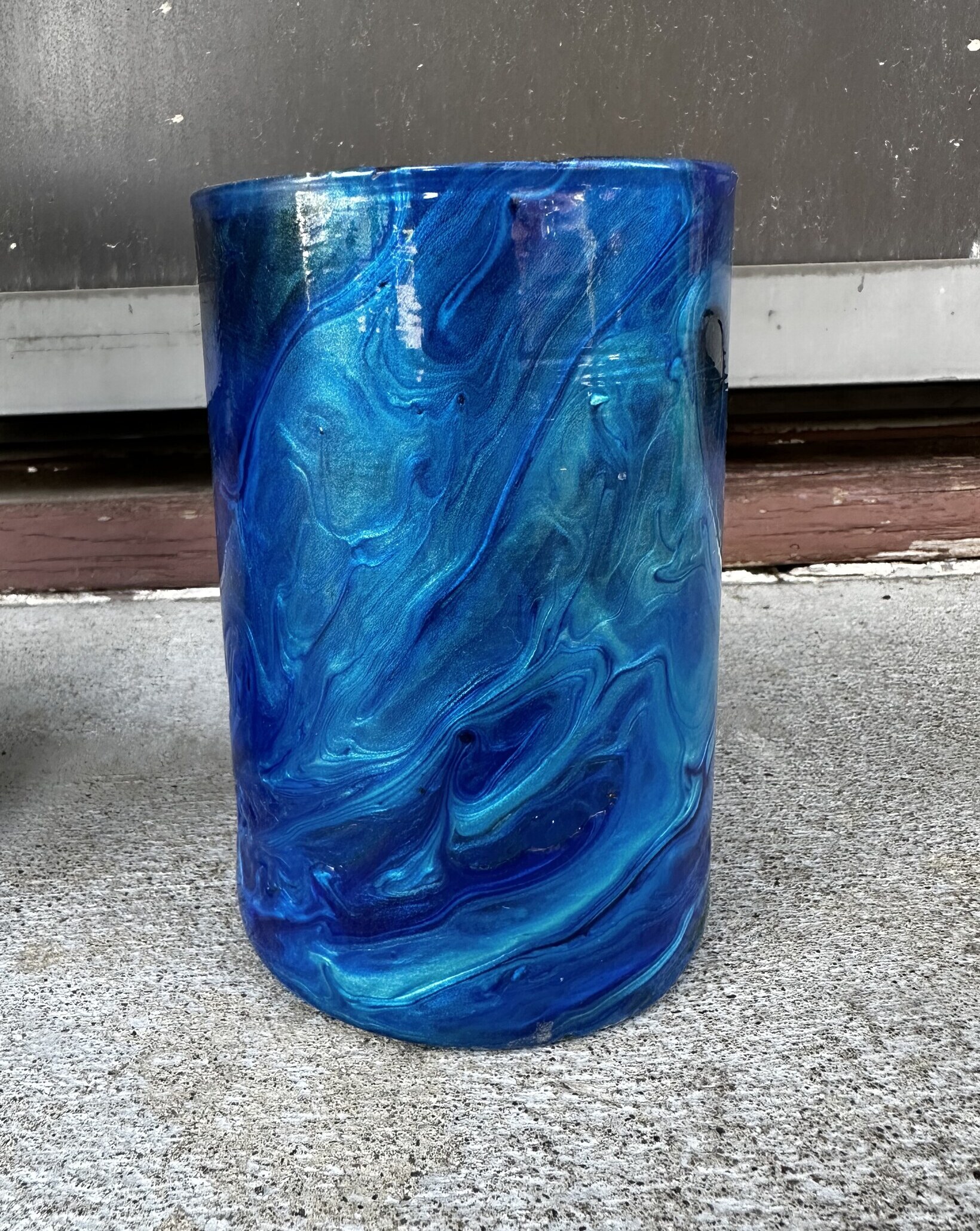 Cylindrical candle jar wrapped in deep blue marbled paint skin