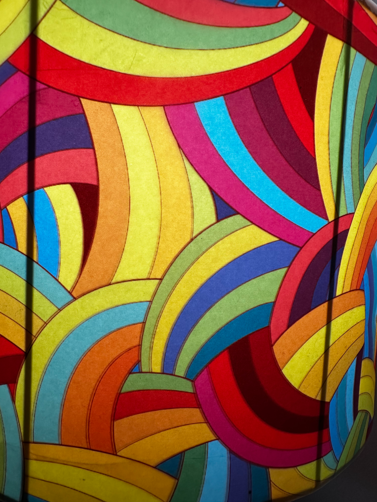 Lamp shade lit from within showing full spectrum rainbow arc pattern