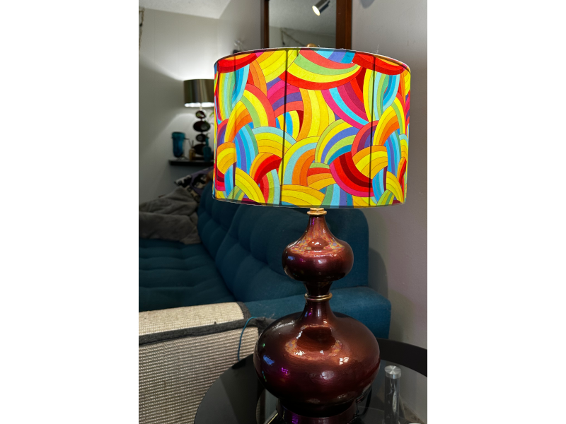 Lamp with full-spectrum rainbow arc shade on iridescent copper base in living room