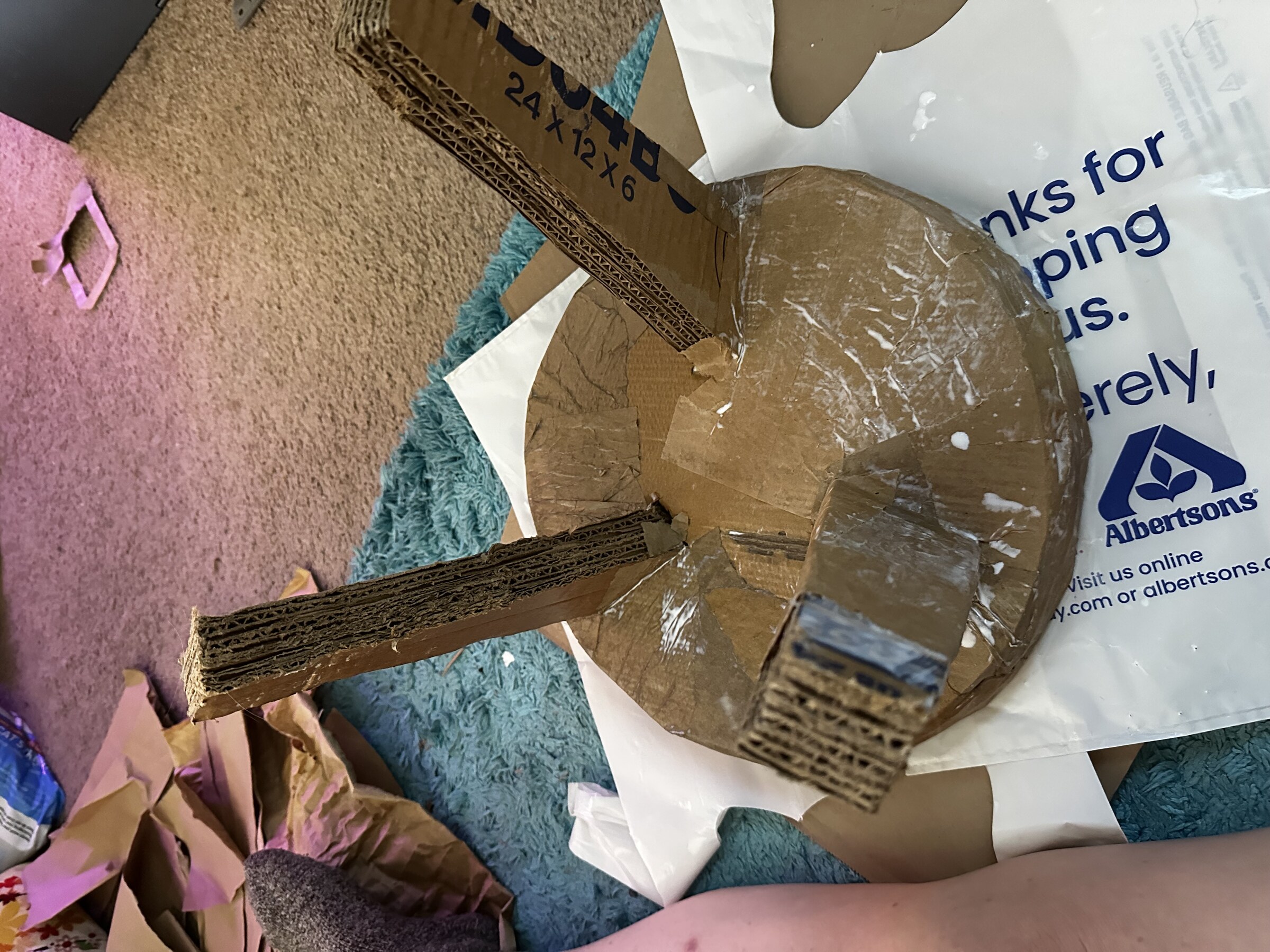 Raw cardboard skeleton of the plant stand, laminated layers visible