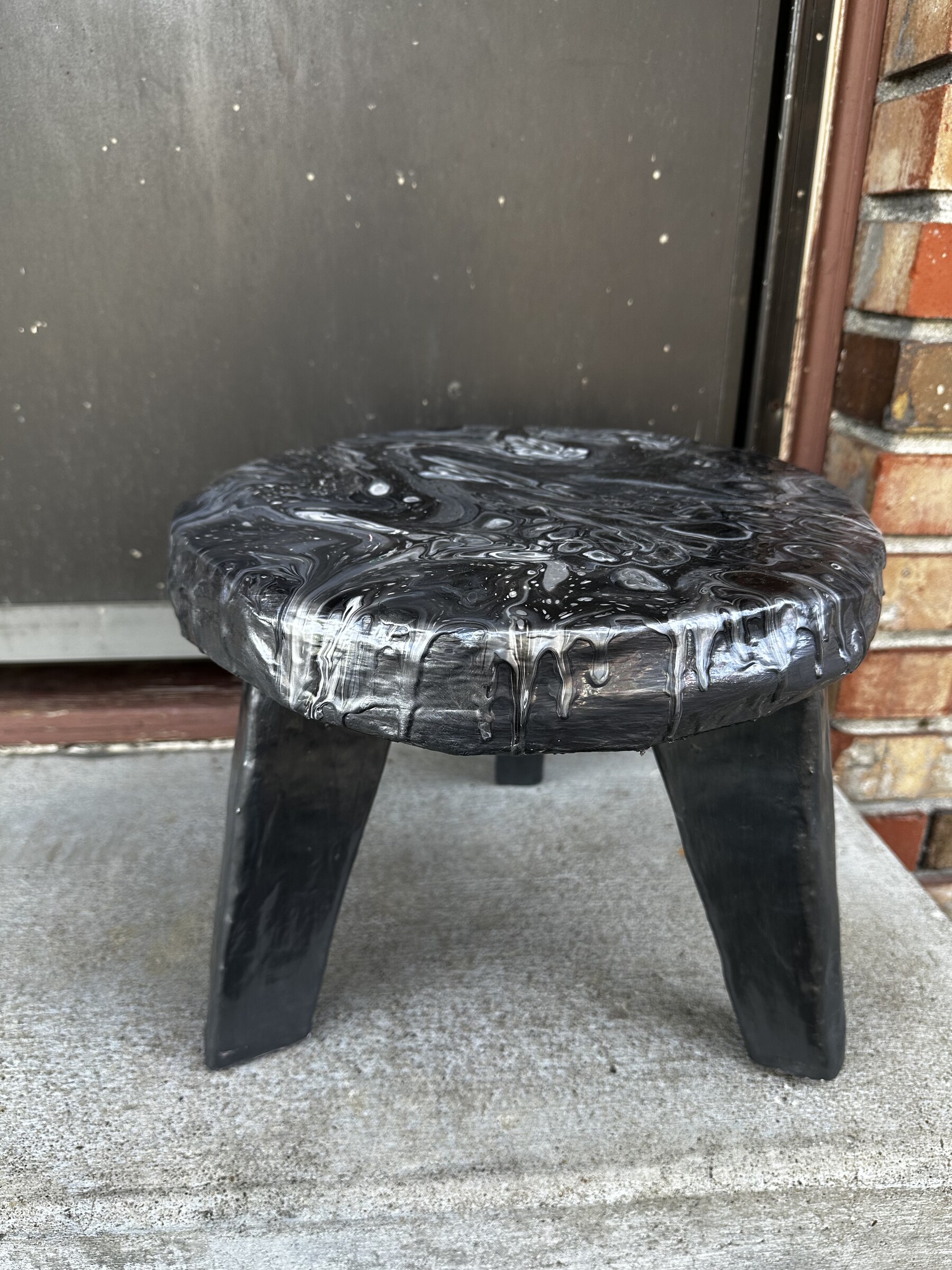 Finished cardboard plant stand outside the front door, black volcanic fluid pour surface