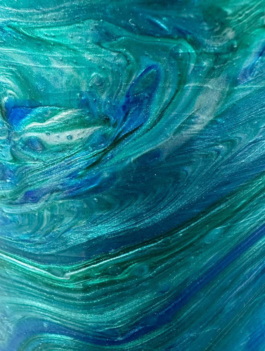 Close-up of the living room vase surface — flowing wave pattern in teal and blue